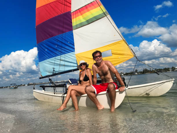 Portrait of heterosexual couple on tropical beach Couple at tropical beach of Sarasota, Florida catamaran sailing stock pictures, royalty-free photos & images