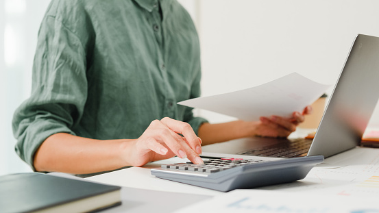 Magnifying glass, calculator and charts on paper symbolizing business and financial market. Blue toned image. studio shot in raw format taken with prime lens for best quality