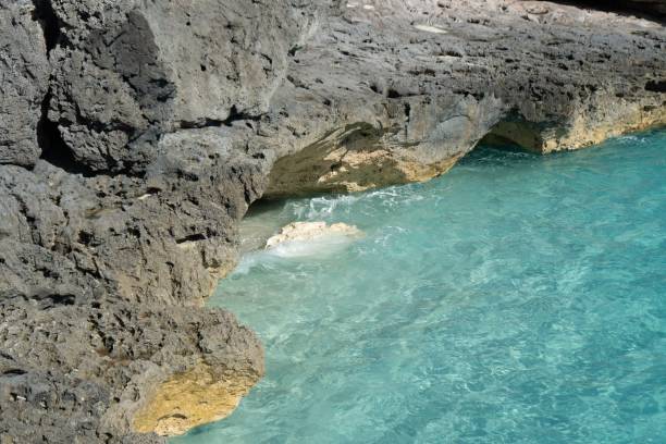 istock Rocky cliff by turquoise clear water sea 1451270908