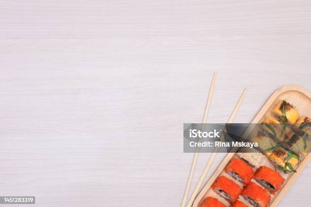 Delicious Japanese Rolls With Salmon Avocado Cucumber Cheese On Wooden Plate With Wood Sticks With Selective Focus Asian Food Concept Healthy Eating Stock Photo - Download Image Now