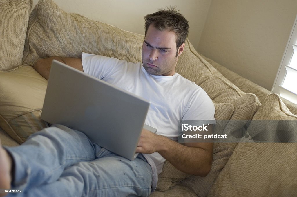 young man relaxing at home young man laying on sofa using laptop computer 20-29 Years Stock Photo