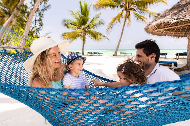 istock Cheerful family talking in hammock on the beach. 1451285054