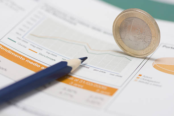 евро монеты на кромке, карандаш и фондовый рынок график - analyzing pie chart scrutiny sales occupation стоковые фото и изображения