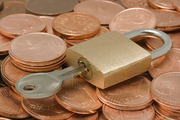 istock Padlock with key on top of a coins pile 145128832