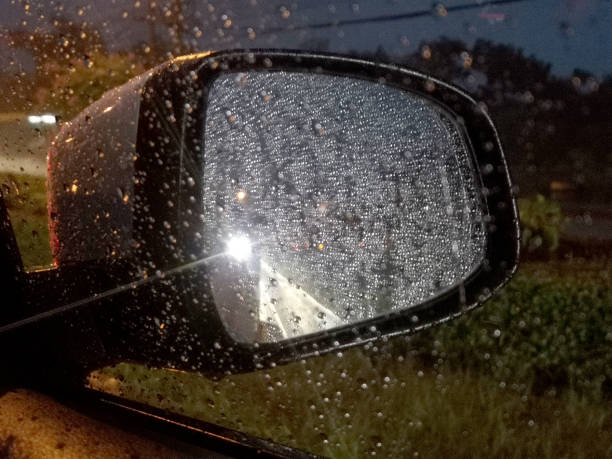 istock View from inside car through window to see wing mirror while of blur background at night time 1451292004