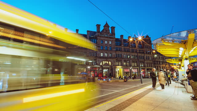 Time lapse of Crowd passengers and tourist walking and waiting tram at station platform at  Exchange Square and Corn Exchange in the city of Manchester, England, UK