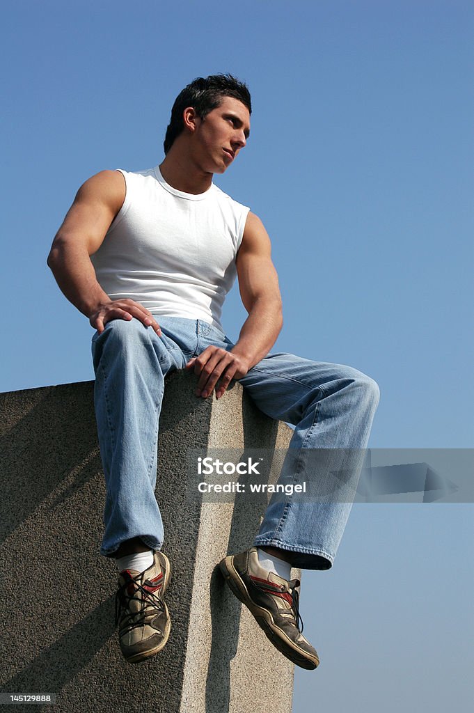 Séance Sexy homme avec un ciel bleu derrière - Photo de A la mode libre de droits