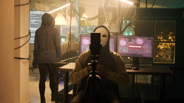 istock Mysterious person with mask broadcasting ransomware video on dark web 1451304448