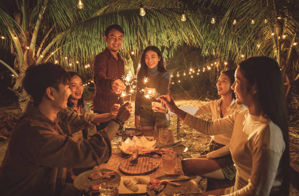 Asian friends together at home have dinner they play fireworks stock photo