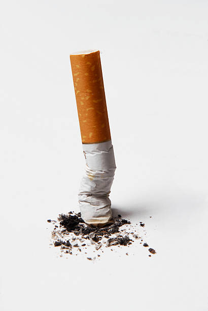 zużyte niedopałek papierosa i popiół na białym tle. - papieros zdjęcia i obrazy z banku zdjęć