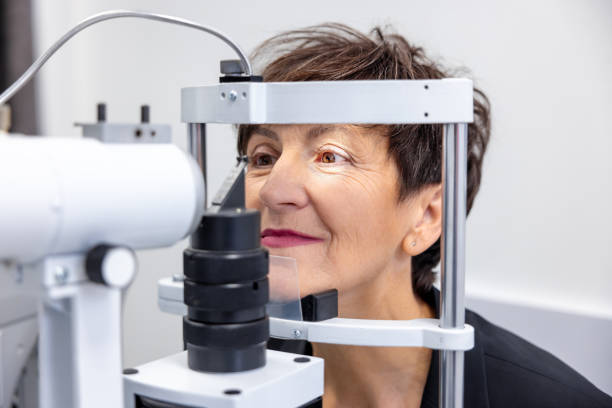 frau mittleren alters besucht die ophtolmologische klinik - optometrie stock-fotos und bilder