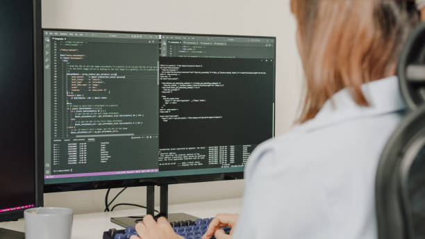 gros plan de jeunes développeuses de logiciels asiatiques utilisant un ordinateur pour écrire du code assises à un bureau avec plusieurs écrans travaillant à distance à la maison. - python photos et images de collection
