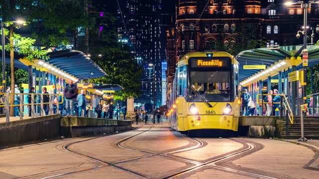 Time lapse of Moving Tram with Crowded Commuter People and Tourist walking and waiting at tram station platform around St. Peter's Square in the city of Manchester, England, UK