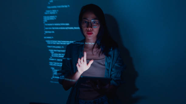 istock Young Asian woman software developers mentor leader manager talking to executive team analyzing source code in office at night. 1451309760