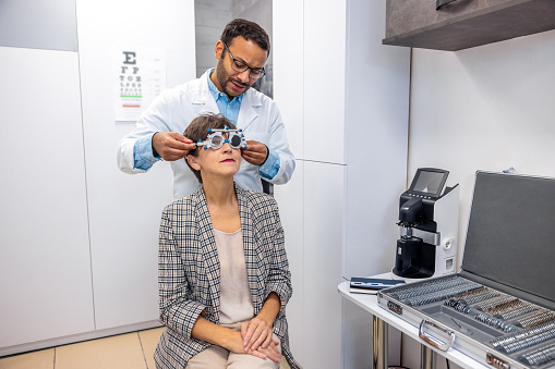 Examining the patient. Optometrist examining a patient at the clinic