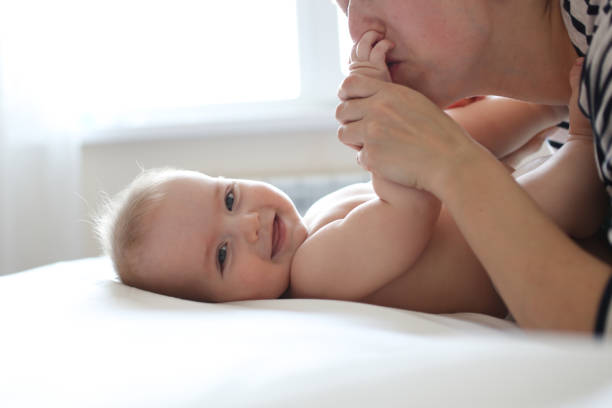 Gentle mother hipster and baby 6 months, care Gentle mother hipster and baby 6 months, tenderness and care, top view. The concept of motherhood and happiness with the baby. Single mom and baby half dozen babies stock pictures, royalty-free photos & images