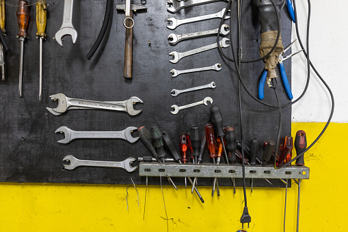 Various tools hanging on the wall in workshop.