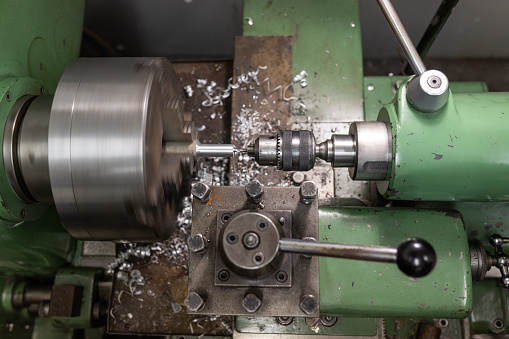 Man worker working with a metal product and welding it with a arc welding machine in a workshop. Industrial manufacturing. Welding metal part in a factory. Orange sparks. Copy space.