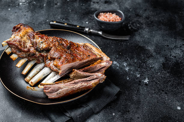 costillar asado de costillas de cordero, costillas de cordero, carne en rodajas en plato. fondo negro. vista superior. espacio de copia - rack of lamb chop cutlet rosemary fotografías e imágenes de stock