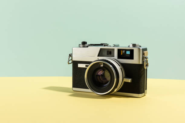 istock Retro camera. Old film camera on a yellow and cyan background 1451315457