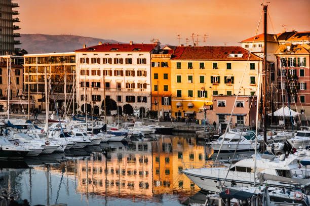Italy, Savona. New port area. Italy, Savona. View, panorama of the port of Savona at sunset. Boats, yachts and the old typical houses are reflected in the water. province of savona stock pictures, royalty-free photos & images