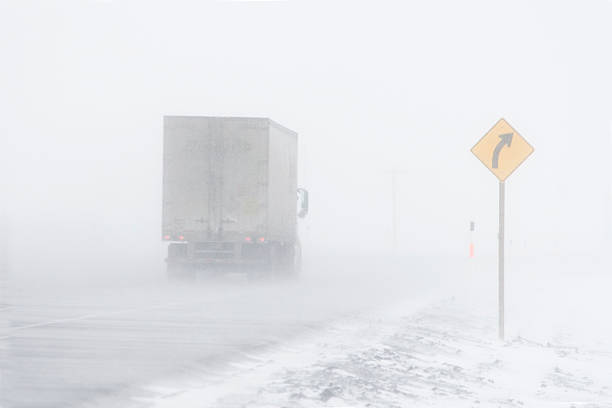 Wind blowing snow across the highway in winter creating limited visability.