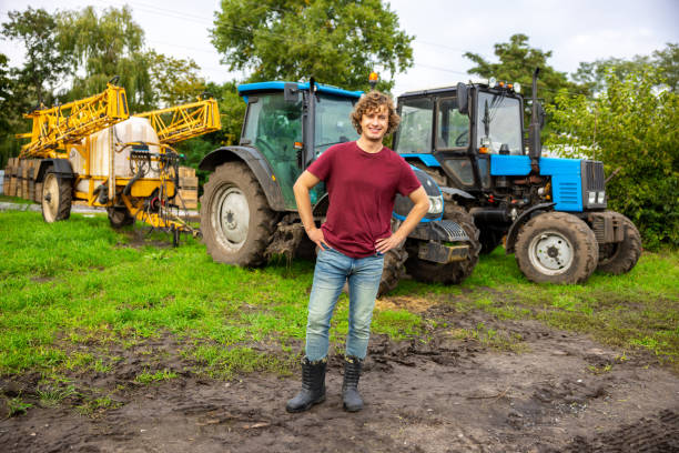 istock Joyous farmer standing in front of the tractor 1451318584