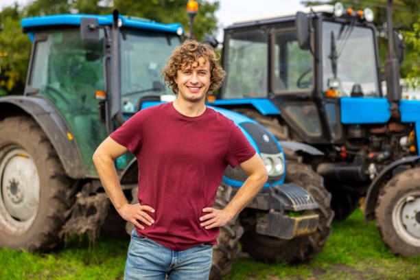 istock Cheerful farmer standing outside between two tractors 1451318687