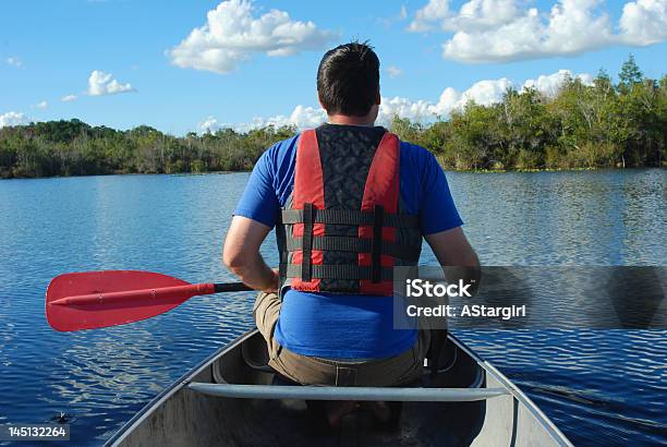 Photo libre de droit de Homme Pagayer Un Canoë banque d'images et plus d'images libres de droit de Adulte - Adulte, Canoë, Ciel