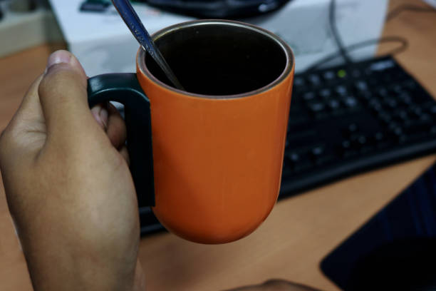 Books, reading eyeglasses and a cup of coffee by laptop