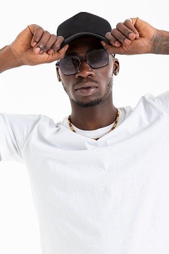 African-American man in white t-shirt wearing sunglasses against white background.