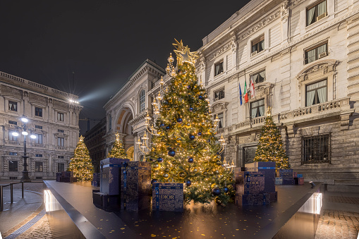 Milan, Italy - December 22, 2022: street view of a Christmas tree in Piazza alla Scala during night time, no people are visible.