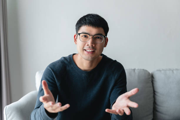 istock Young Asian man seriously explain talking on the couch. online video conference call, job interview, meeting. 1451336710