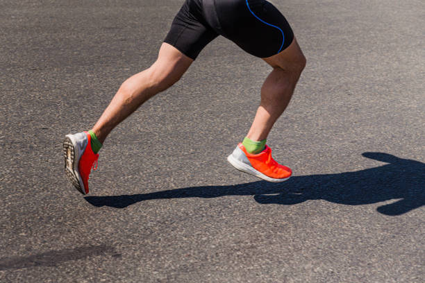 legs runner in bright shoes running on asphalt