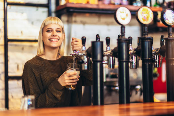 istock Female bartender tapping beer in bar. 1451342281