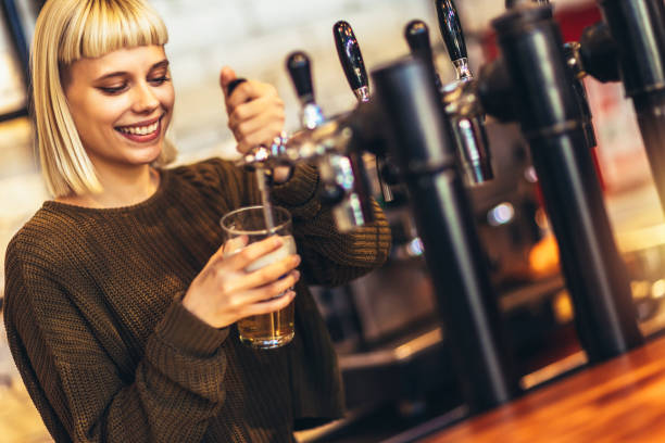 istock Female bartender tapping beer in bar. 1451342310