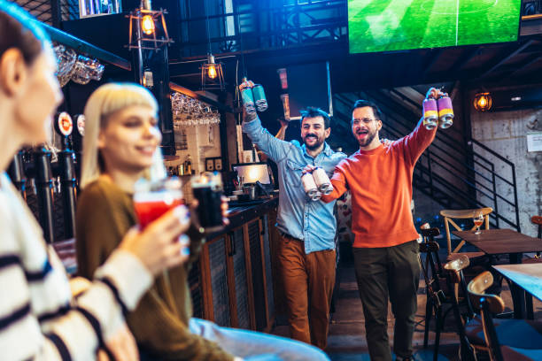 istock Smiling young friends drinking craft beer in pub 1451342540