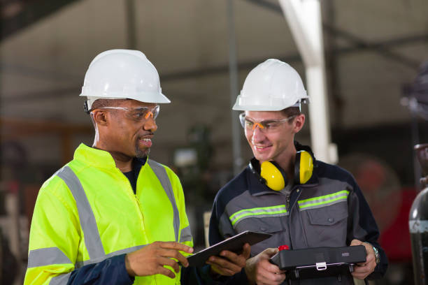 istock Two male engineer workers discuss and holding digital tablet working in the industry factory 1451343641