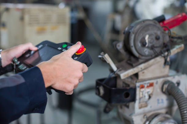 istock Hands of male engineer using robot controller working with welding robot arm in workshop. Male technician worker control, setup automatic welding robot arm at industry factory 1451343654