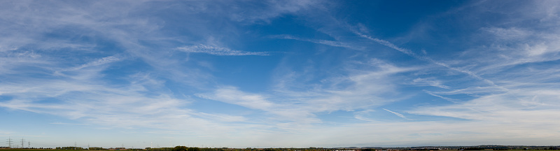 Blue-white cloud background with cirrostratus clouds and contrails