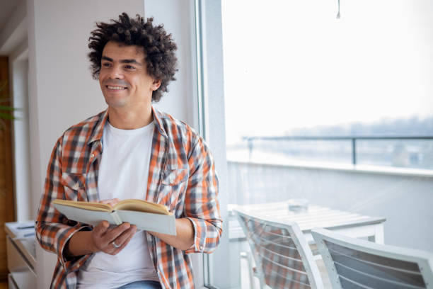 istock Man reading a book at home 1451348725