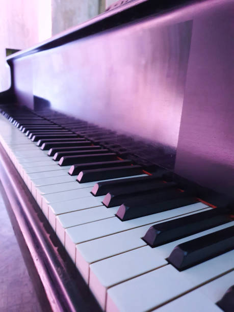 istock White black piano keys in purple light. Musical event. Close-up view 1451352169