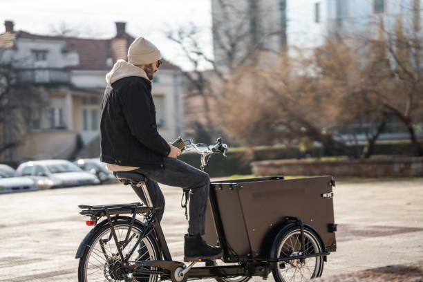 istock Man riding cargo bicycle in city on a cold autumn day 1451358867