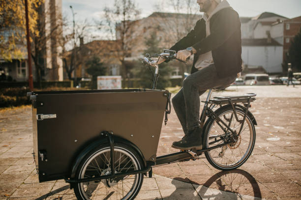 istock Man riding cargo bicycle in city on sunny autumn day 1451359034