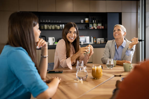 Happy businesswomen talking on a break in cafeteria.