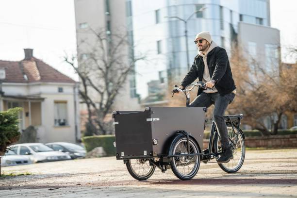 Handsome man riding his cargo bike in the city stock photo