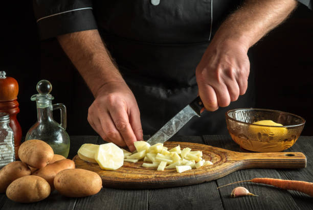 istock Before preparing the national dish, the chef cuts raw potatoes into small pieces with a knife. Close-up of a cook hands while working in a restaurant kitchen 1451362807