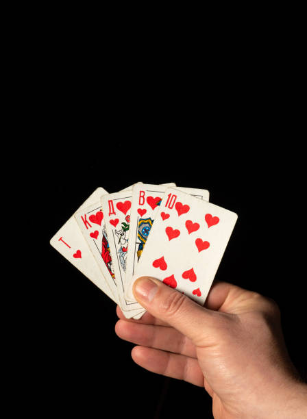 istock Close up male hand holding Royal Flush cards while playing poker 1451364556