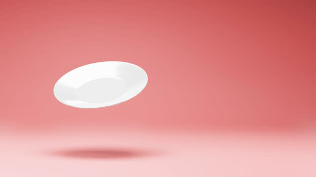 One White Plate Spinning on Studio Red Background
