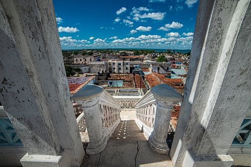 A high angle shot of white stairs leading down to Cienfuegos city in Cuba